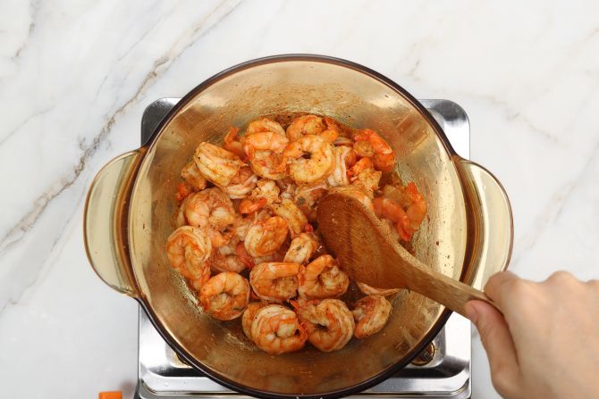 step 5: In the same stockpot, sauté shrimp with spices.