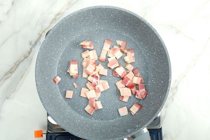 step 2: Add sliced bacon to a non-stick frying pan. Stir the bacon over medium heat, until crispy.